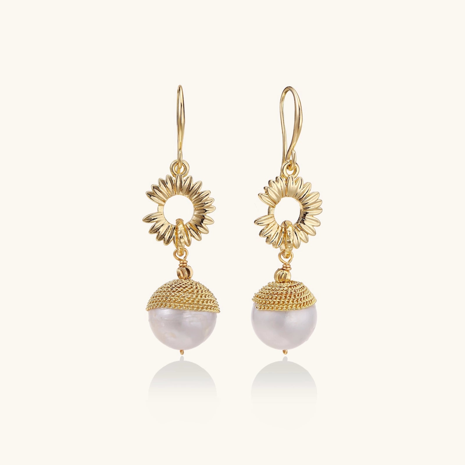 Sunburst pearl dangle earrings in 14K gold with baroque pearl drop on white background