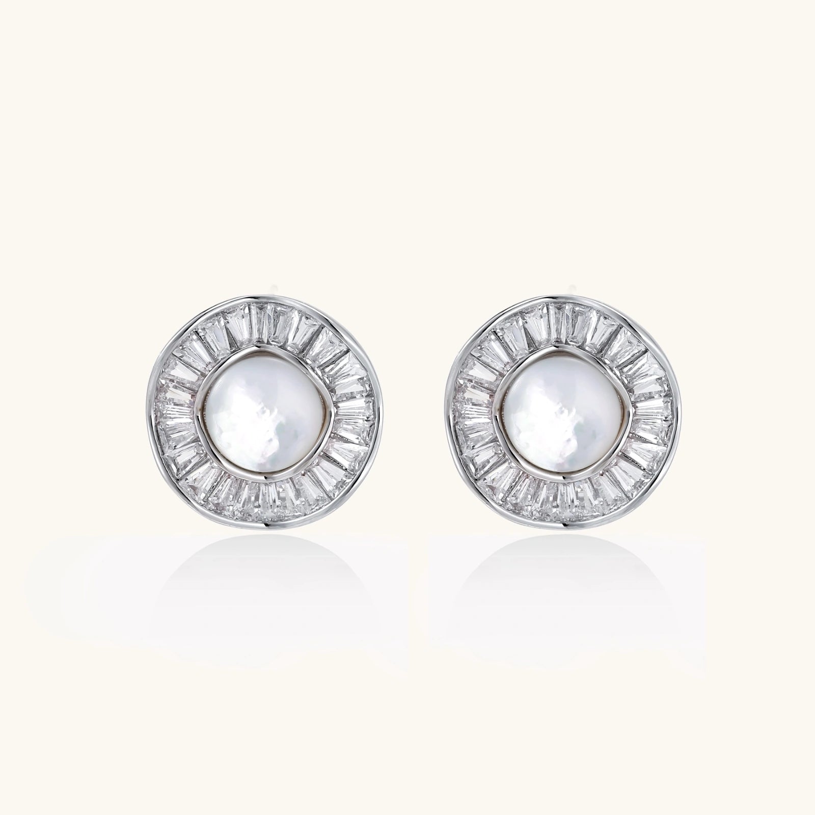 Sunburst pearl stud earrings in white gold with baguette crystal halo on white background