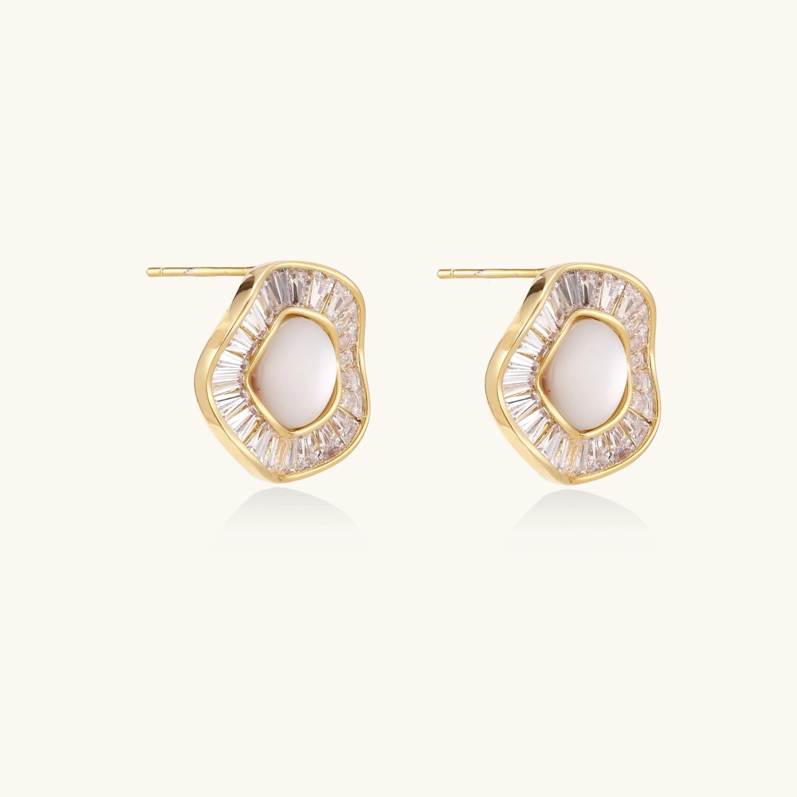  Close-up of baguette crystal halo on yellow gold sunburst pearl stud earrings