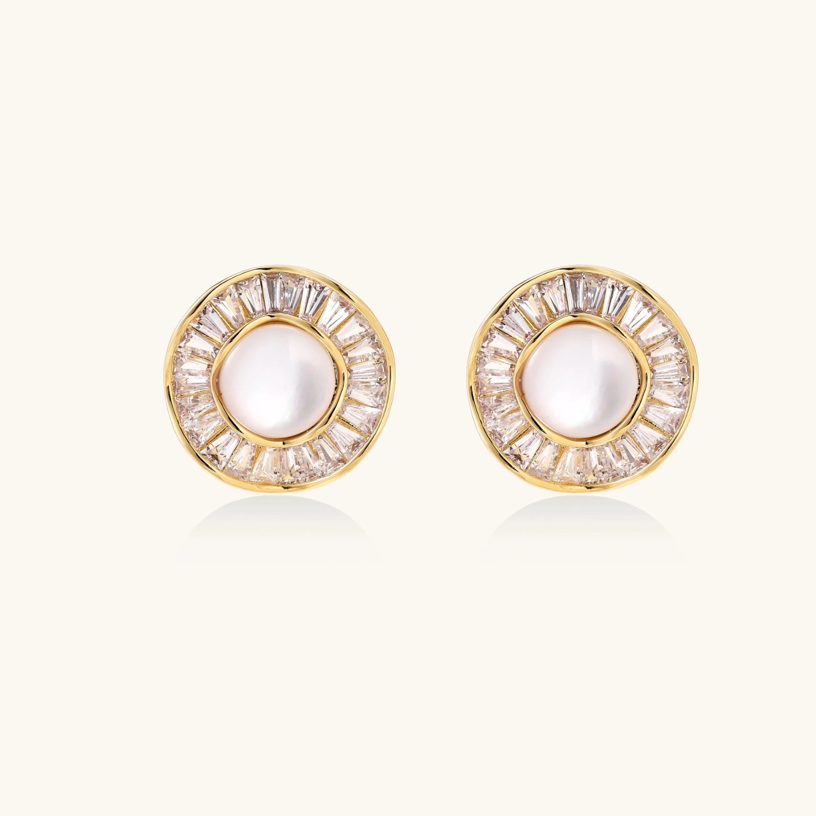 Sunburst pearl stud earrings in yellow gold with baguette crystal halo on white background