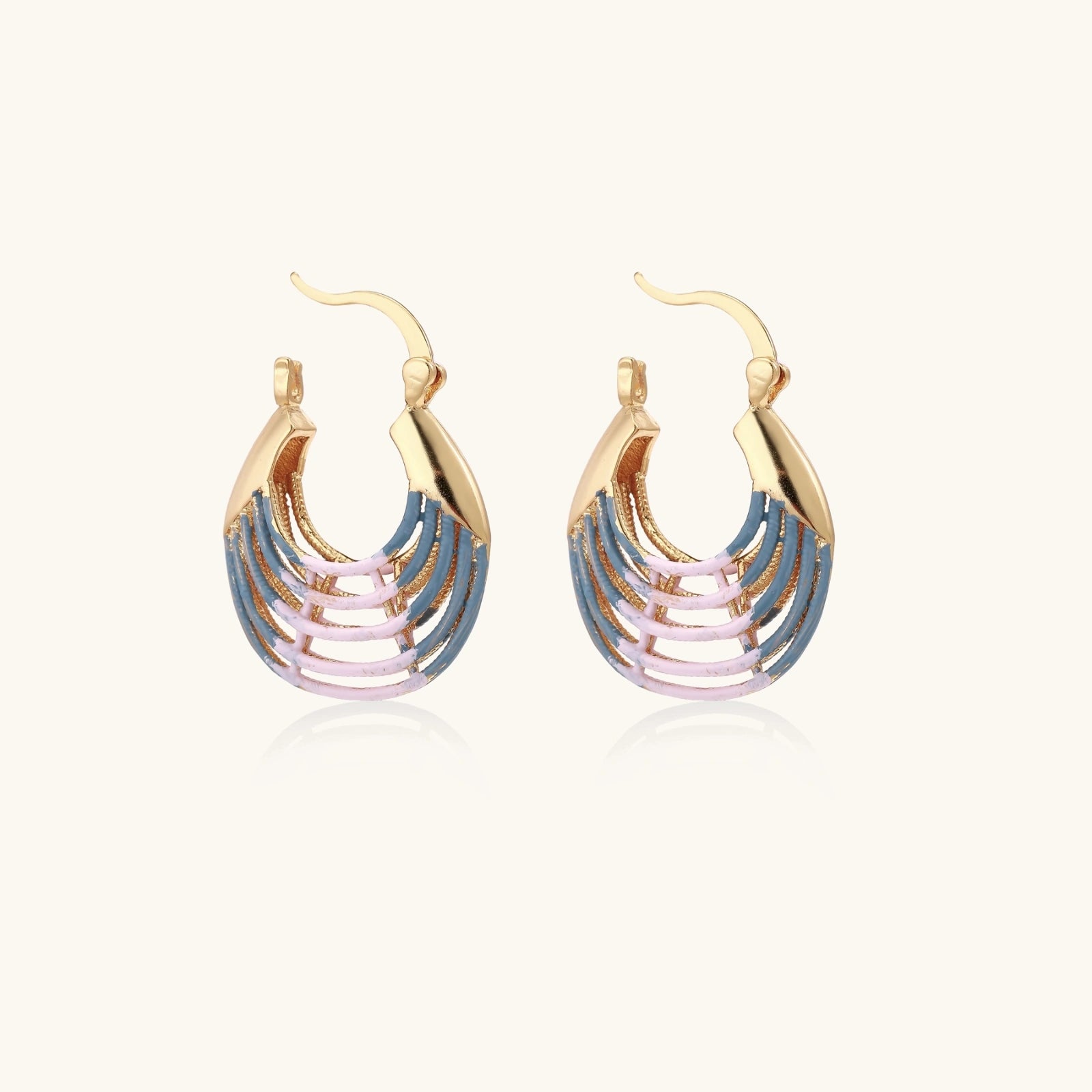 Side view of gold sunrise ripple hoop earrings with striped enamel detail