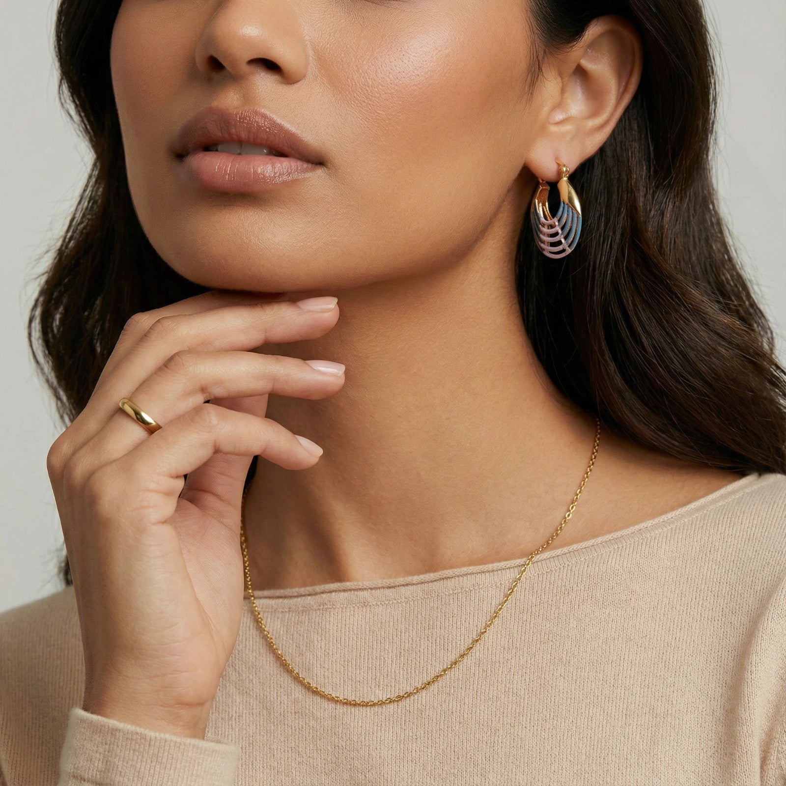 Woman wearing sunrise ripple hoop earrings — coastal aesthetic statement jewelry